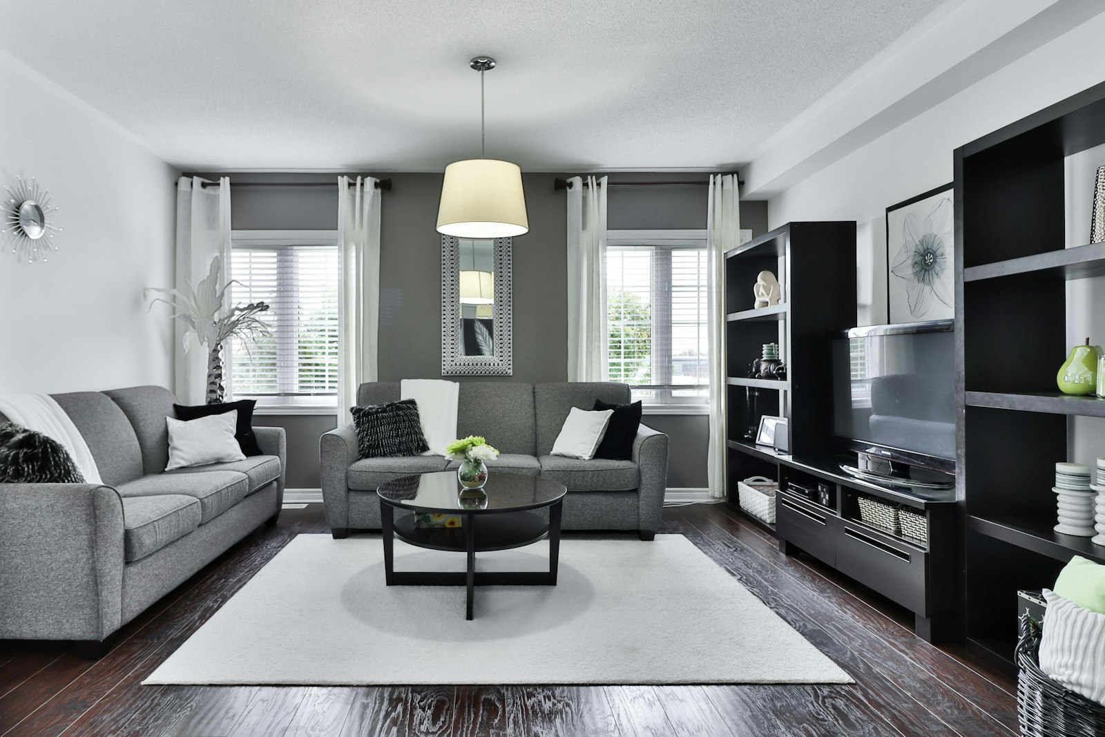 Grey sofa with a round oak coffee table in a bright living room