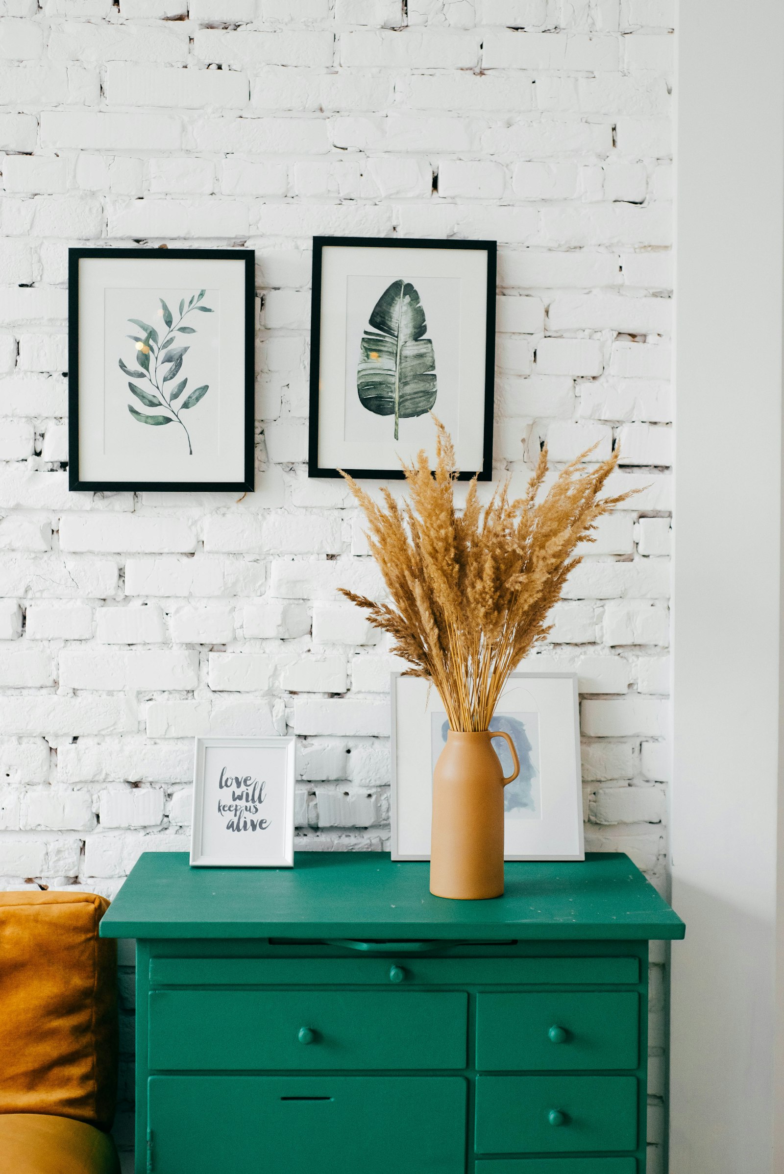 Framed botanical prints on a white brick wall