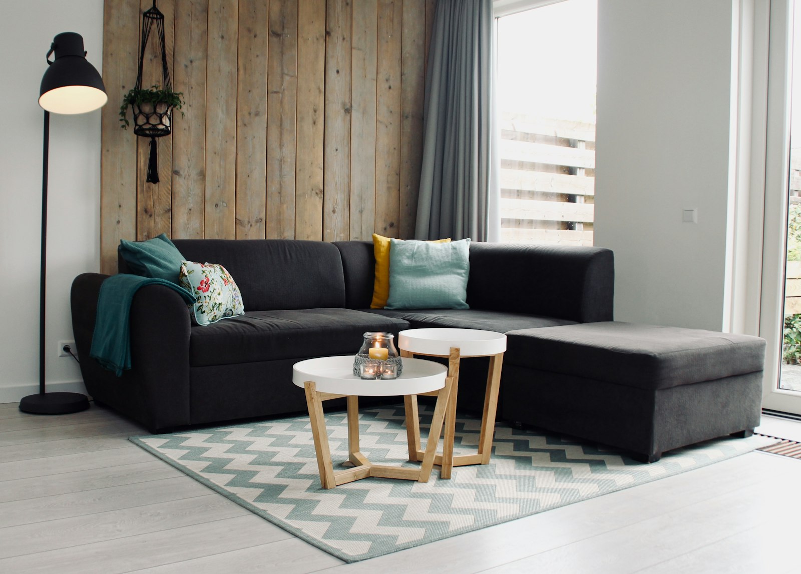 Grey sectional sofa against a warm wood panel wall