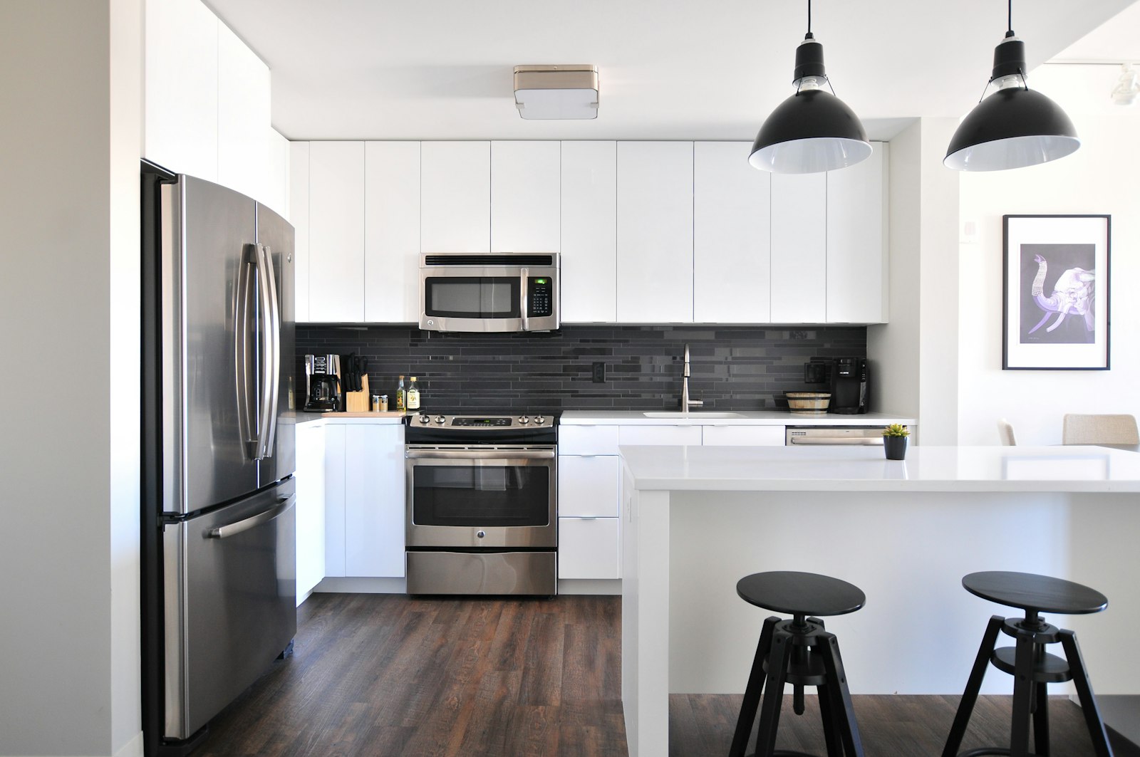 White kitchen island with black pendant lights