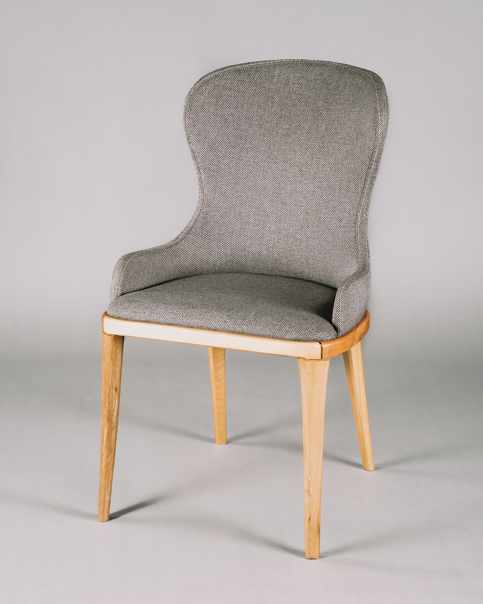 Dove grey upholstered dining chair on a white background