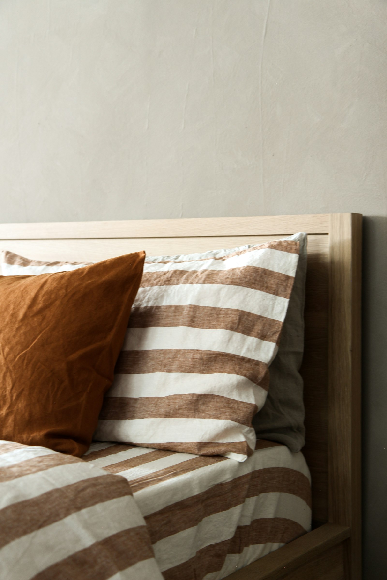 Bed made with layered bedding and cushions