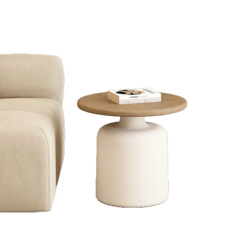 Small 50 cm round coffee table with a white pedestal base next to a boucle armchair