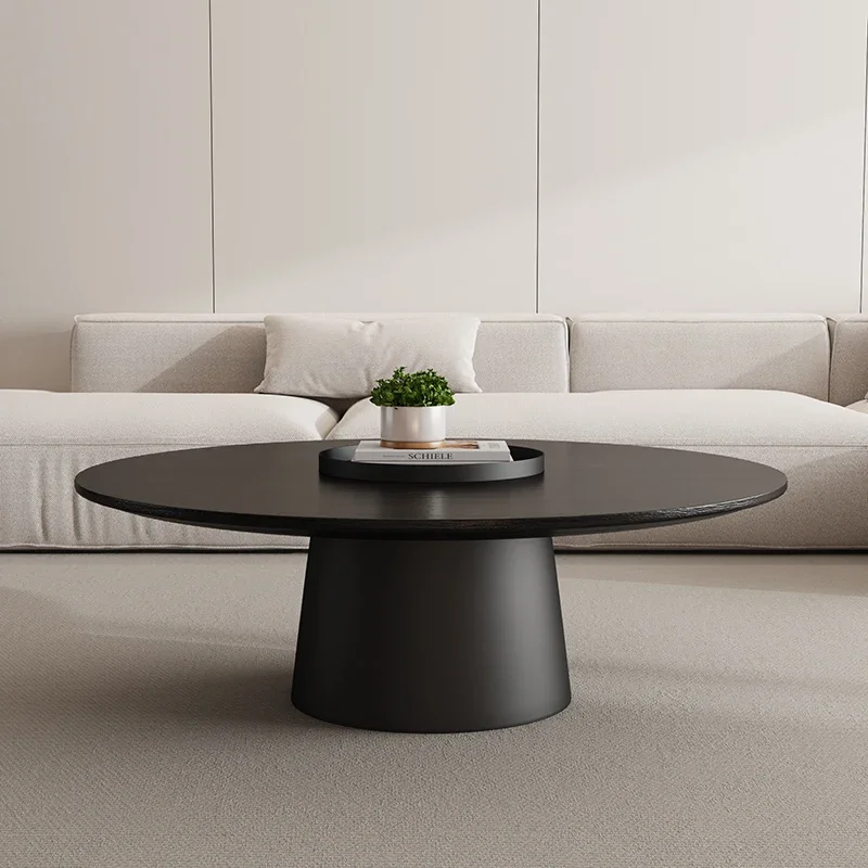 Black-top version of the round pedestal coffee table in front of a pale sofa