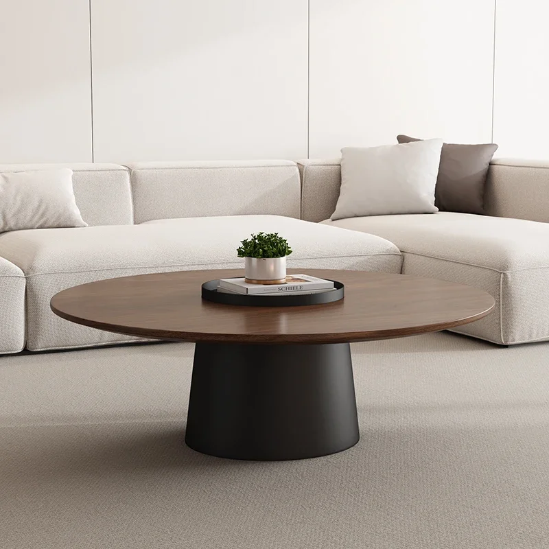 Round walnut-tone coffee table in front of a cream sectional sofa